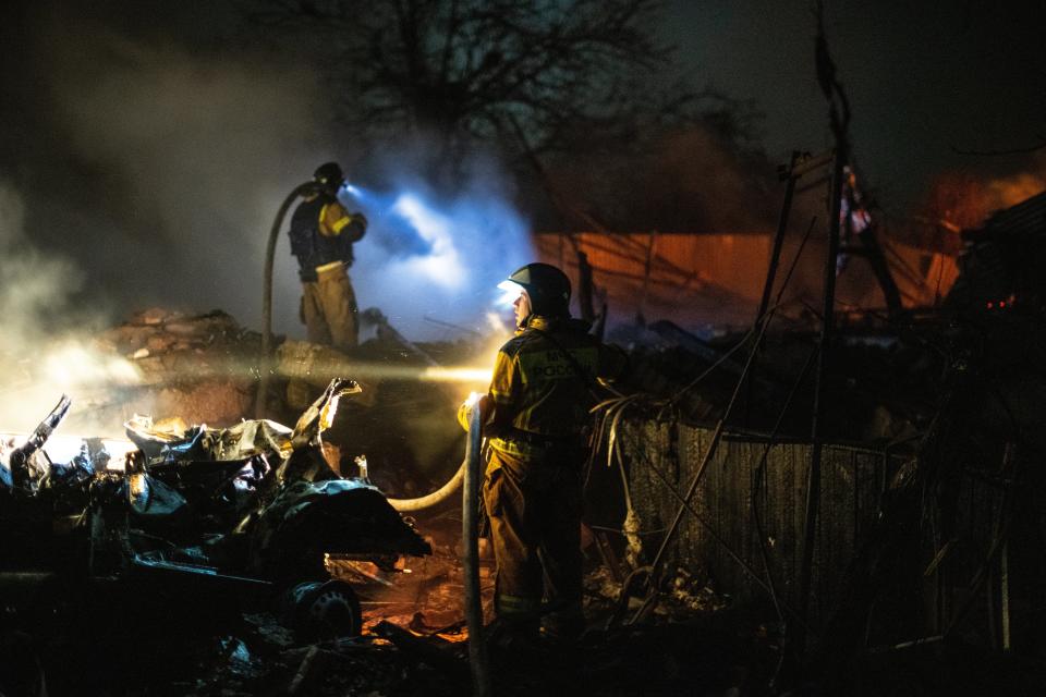 Firefighters working on the remains of houses in the Donetsk region (EPA)