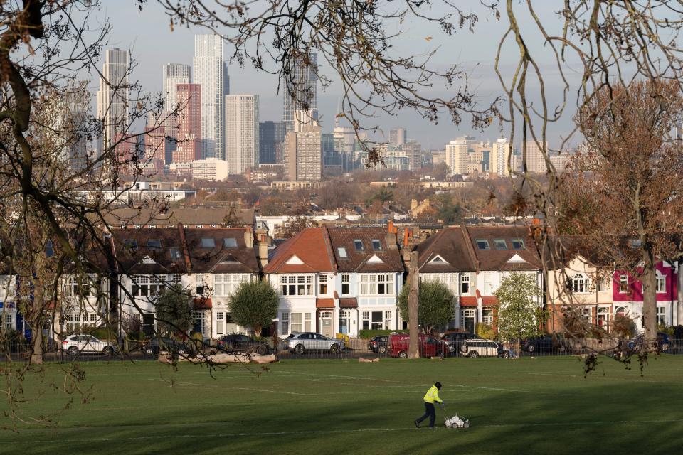 Infront of Lambeth homes and the skyline of Nine Elms in the distance, an employee marks the white lines on a football pitch in Ruskin Park, a public green space used for local, youth and amateur league matches, on 29th November 2023, in London, England.