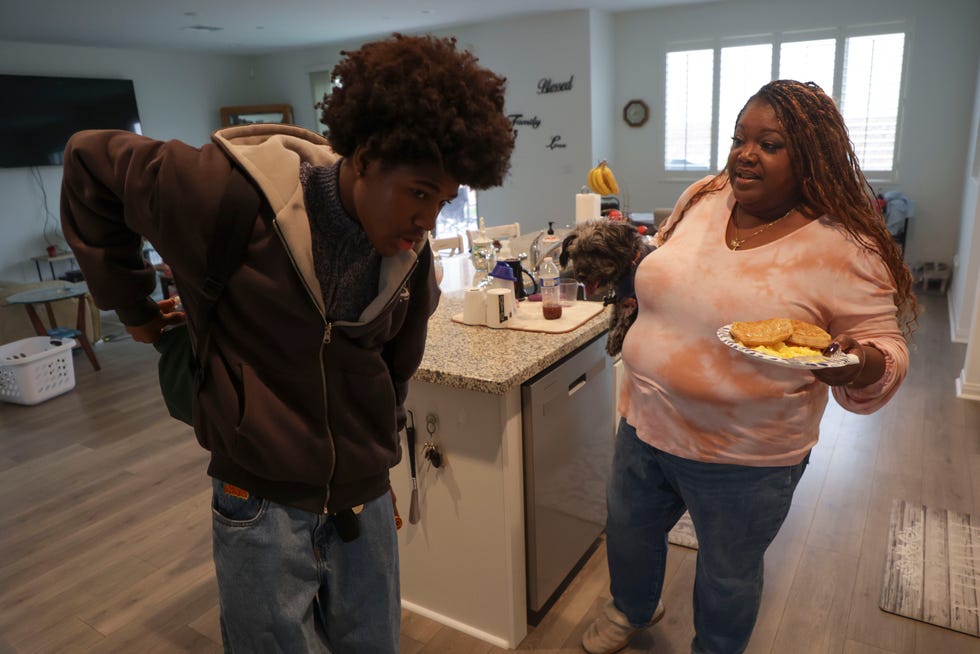 Jeremiah Davis, 16, prepares to go to school as Cynthia Davis, 52, and her dog Mason walk Jeremiah to the car on Nov. 16, 2023.