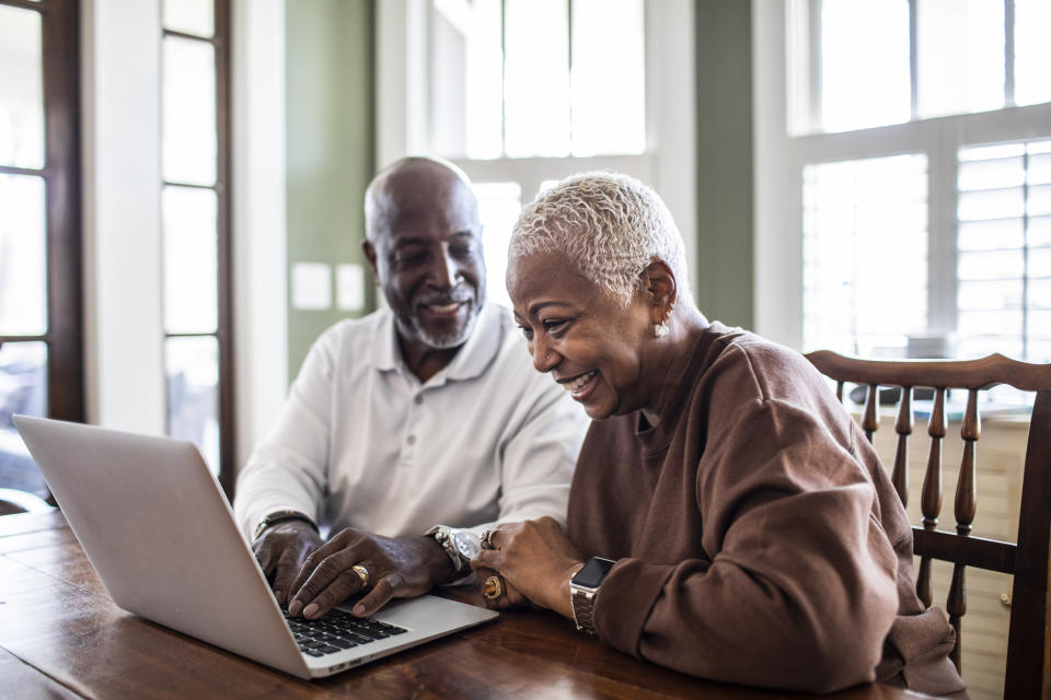 Senior couple using laptop at home pension