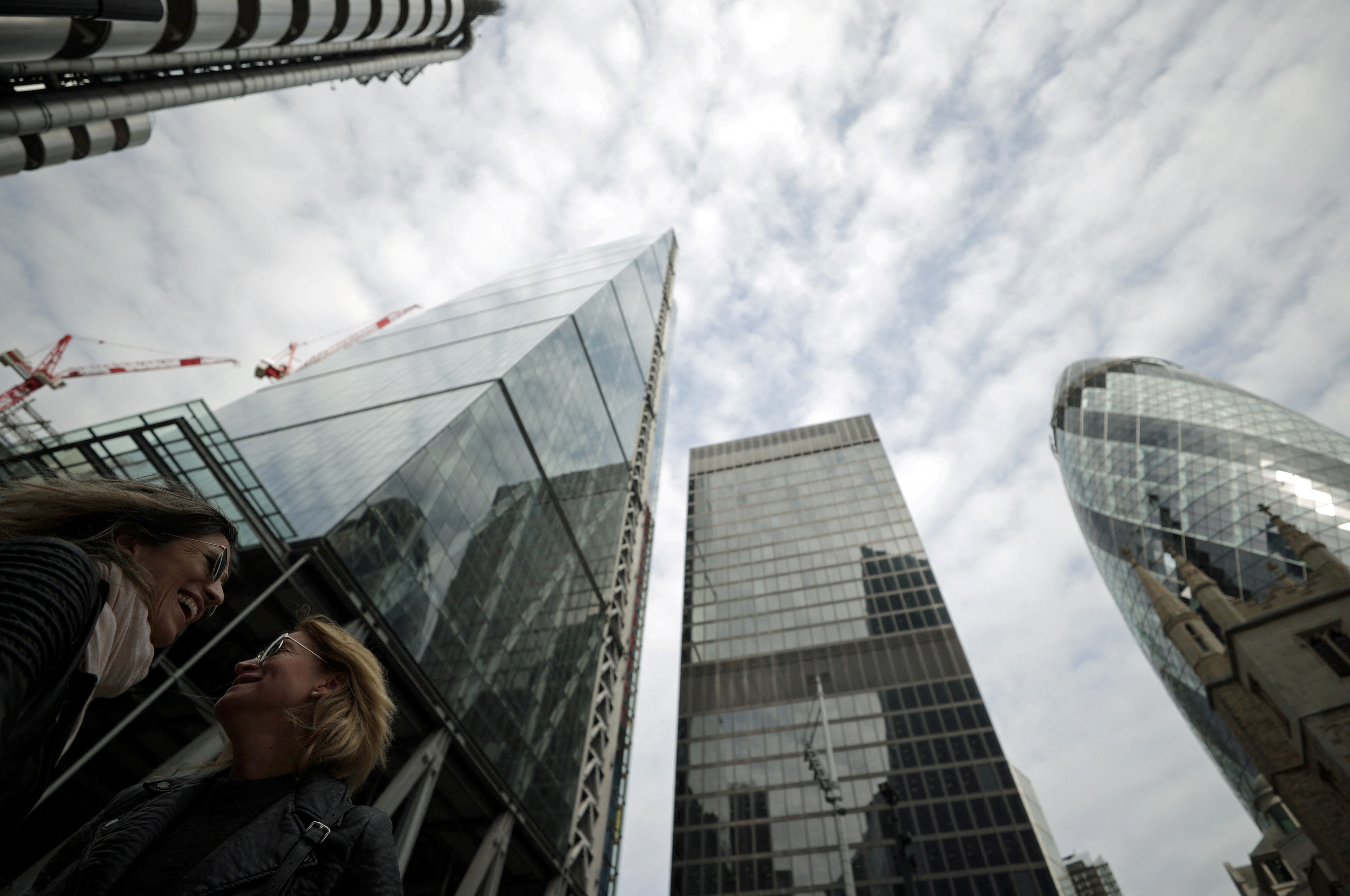 People walk through the City of London financial district in London