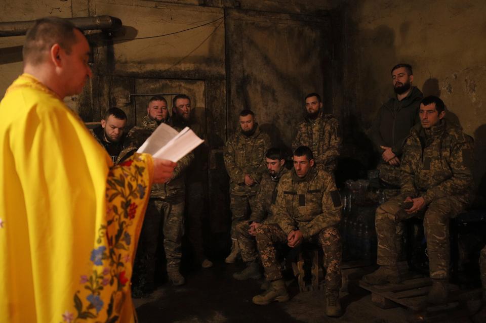 Chaplain Ivan of the Orthodox Church of Ukraine reads a prayer for Ukrainian servicemen of the 72nd mechanized brigade (AP)