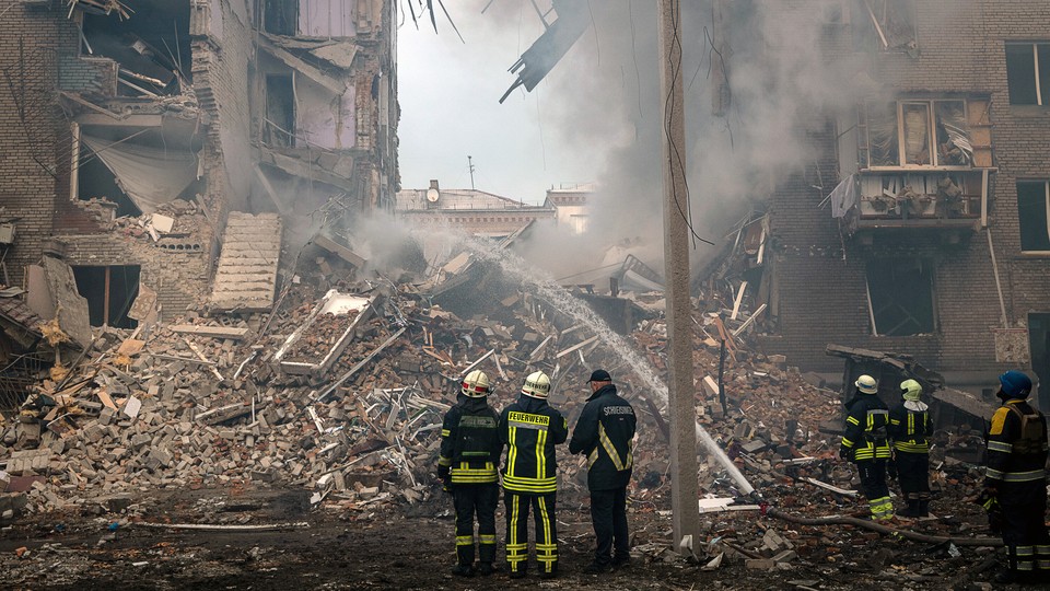 Firefighters and rescue workers at the scene of a Russian missile strike on Zaporizhzhya, Ukraine