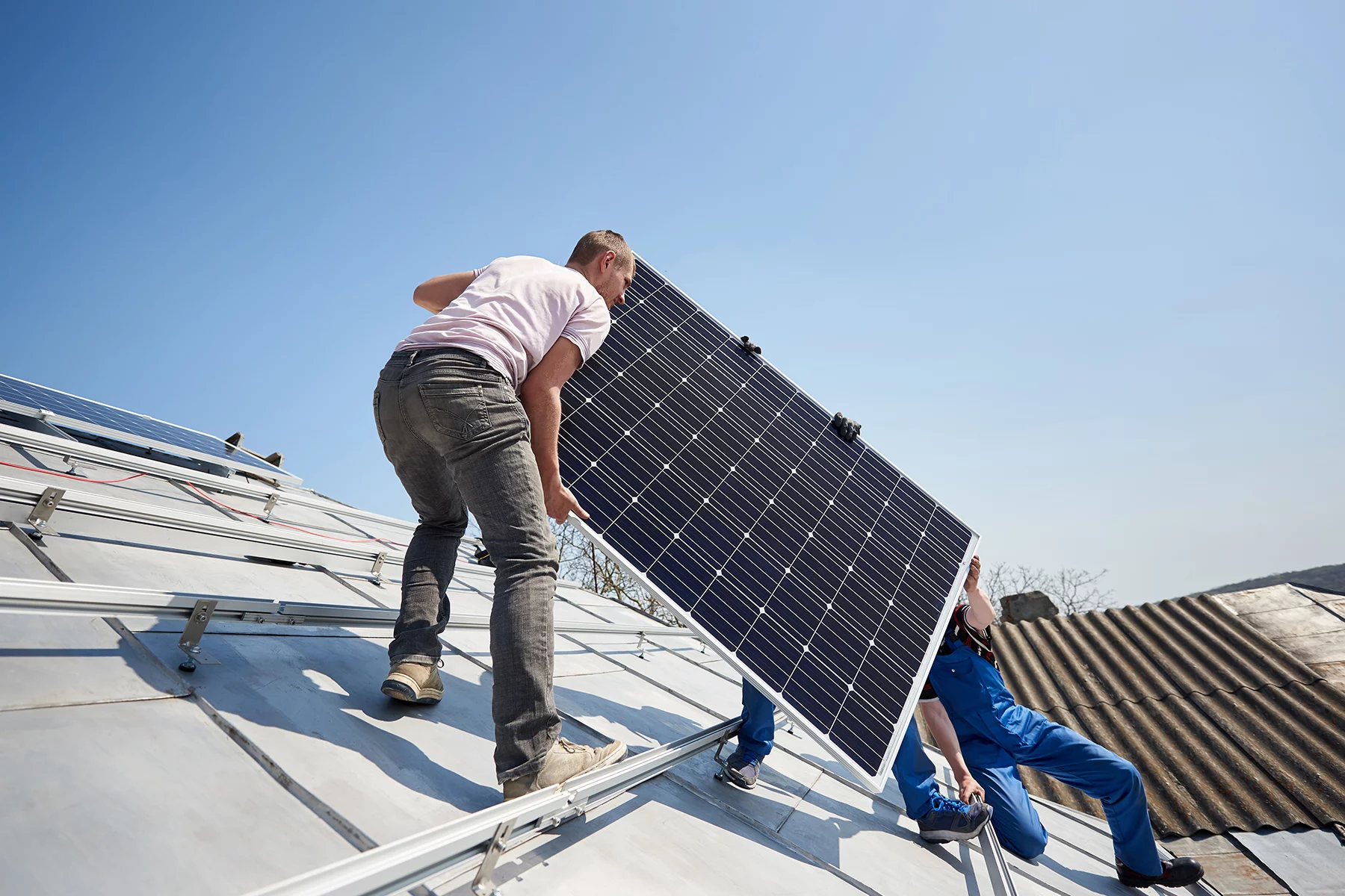 Men installing solar panels on the roof of a home