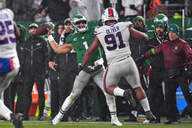 Nov 26, 2023; Philadelphia, Pennsylvania, USA; Philadelphia Eagles quarterback Jalen Hurts (1) throws touchdown pass in fourth quarter under pressure form Buffalo Bills defensive tackle Ed Oliver (91) at Lincoln Financial Field. Mandatory Credit: Eric Hartline-USA TODAY Sports