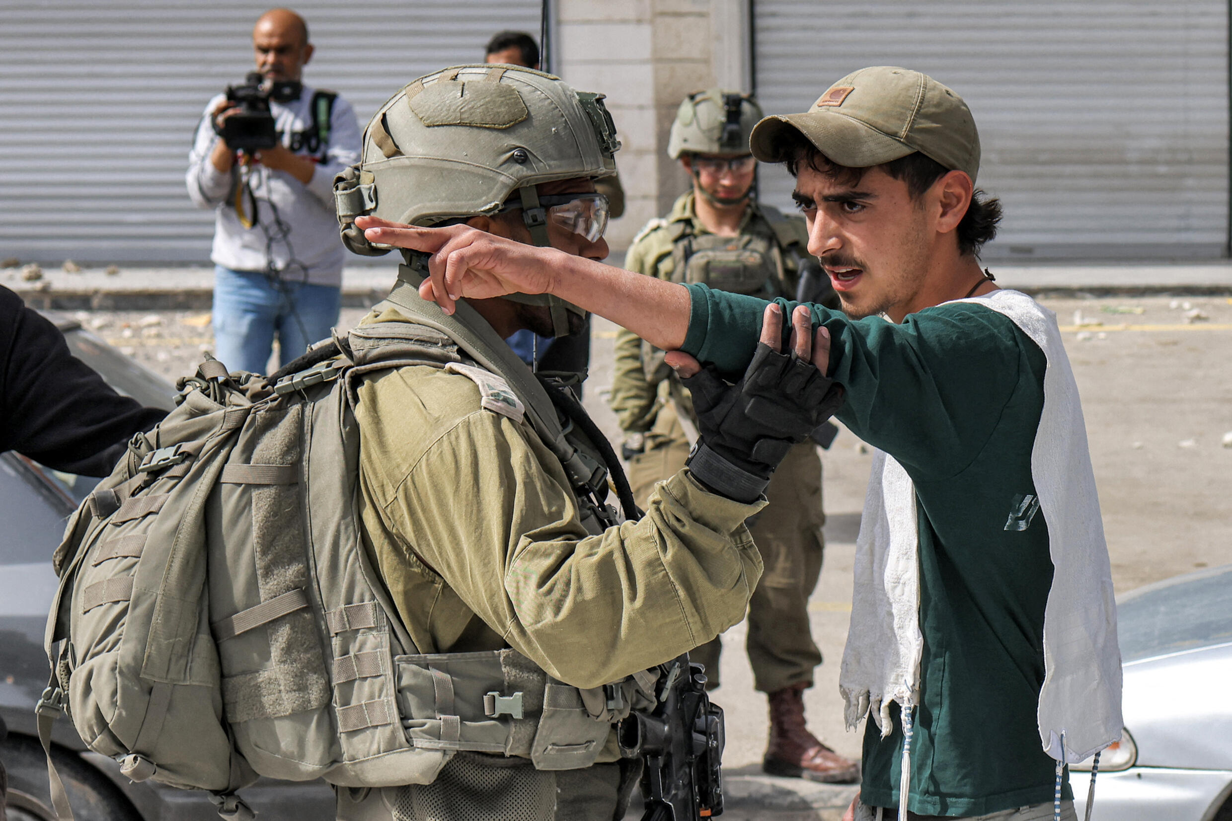 An Israeli soldier speaks with an Israeli settler in the town of Huwara near Nablus in the occupied West Bank, on February 27, 2023.