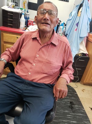 Benson Daniels, 73, smiles from the barber's chair in December 2021. Days later, he was killed while crossing a street in downtown Gallup, N.M.