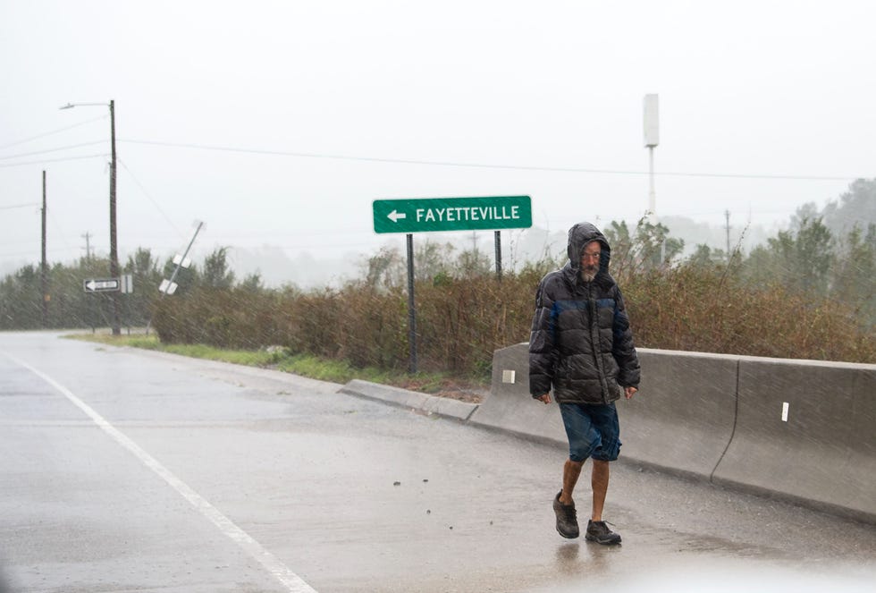 A person walks along a highway in Lumberton, N.C. in fall 2018. The county's majority Native American and Black population struggles with one of the state’s worst traffic fatality rates. It hasn't won any money through the Safe Streets and Roads for All grant program.