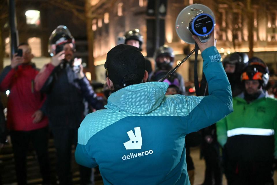 A Deliveroo driver addresses fellow takeaway delivery drivers at Notting Hill Gate in west London on Wednesday, during a strike to demand better pay and conditions.