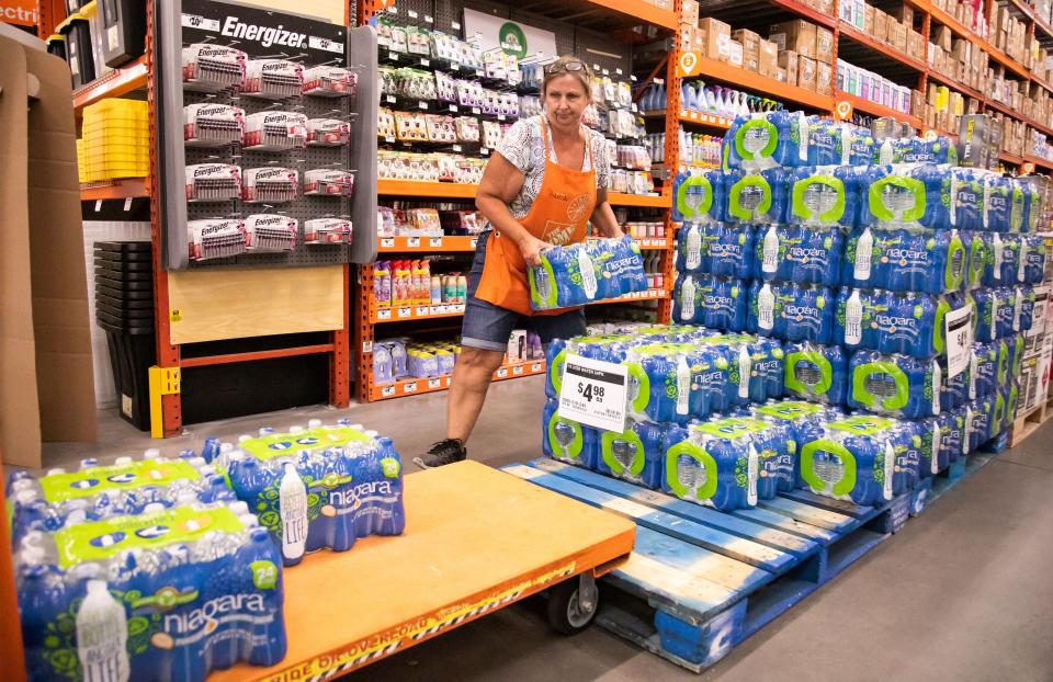 A Home Depot employee fills a cart with cases of water while moving them to the front door in August at a location in Ocala, Florida as the region braced for Tropical Storm Idalia.