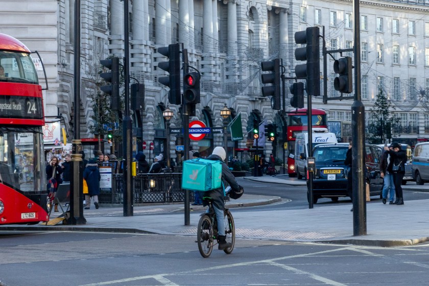 A food delivery courier working for Deliveroo Plc cycles through Piccadilly Circus in central London, UK.