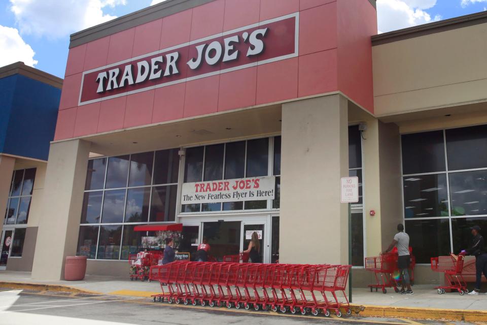 People stand in line waiting to enter Trader Joe's to buy groceries in Pembroke Pines, Fla., on March 24, 2020.