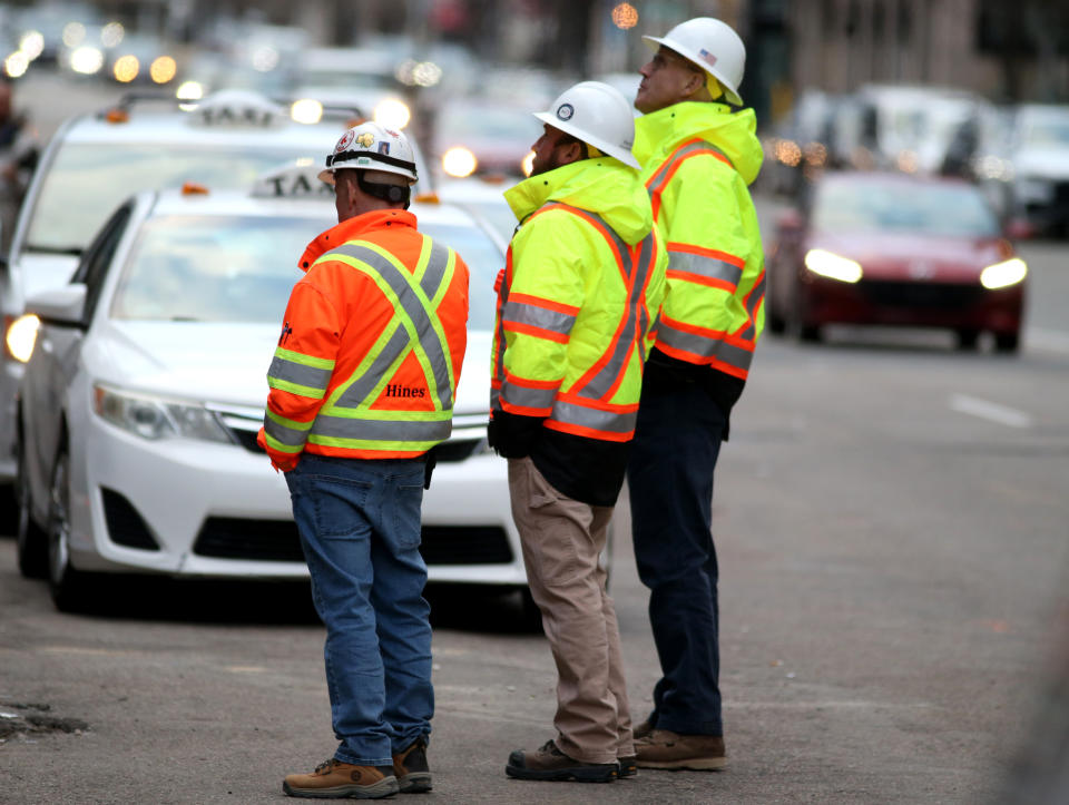 Boston, MA - March 20: Construction workers look up at damage to the South Station Tower. (Photo by Jonathan Wiggs/The Boston Globe via Getty Images)