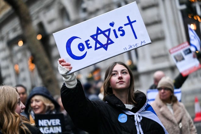 A protester holds reading "Coexist" during a demonstration in central London, on November 26, 2023, to protest against antisemitism.