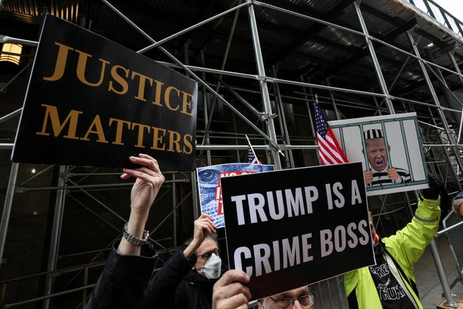 Anti-Trump protestors hold a placards outside Manhattan District Attorney Alvin Bragg's office as the investigation continues into $130,000 paid in the final weeks of former U.S. President Donald Trump's 2016 election campaign to Stormy Daniels, a porn star who said she had a sexual encounter with Trump in 2006 when he was married to his current wife Melania, in New York City on March 24, 2023.