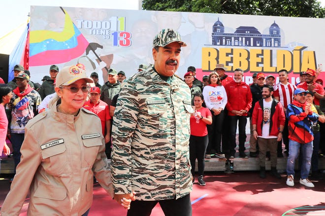 This handout picture released by the Venezuelan Presidency shows Venezuelan President Nicolas Maduro (C) and First Lady Cilia Flores arriving at a political rally in Caracas on April 13, 2024. Venezuelan President Nicolás Maduro proposed on Saturday a constitutional reform to establish life imprisonment and political disqualifications for life for corruption and treason crimes in the South American country, where the highest penalty is 30 years in prison. (Photo by ZURIMAC CAMPOS / Venezuelan Presidency / AFP)