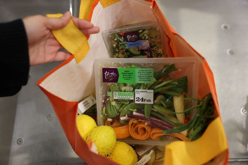 © Reuters. FILE PHOTO: A customer puts groceries inside a reusable bag at the self-checkout inside a Sainsbury's supermarket, in Richmond, West London, Britain February 21, 2024. REUTERS/Isabel Infantes