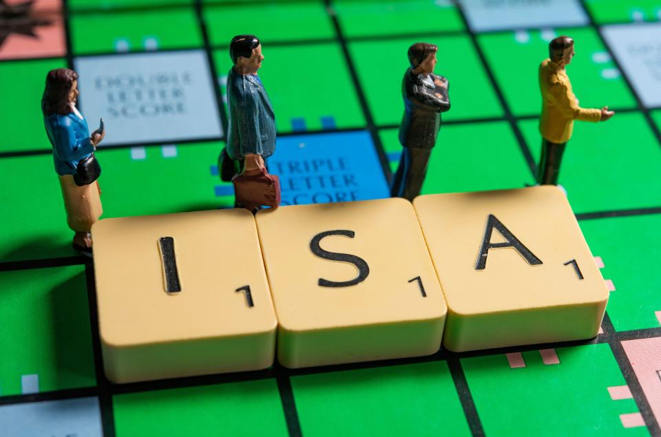 miniature figurines next to ISA letter on a scrabble board