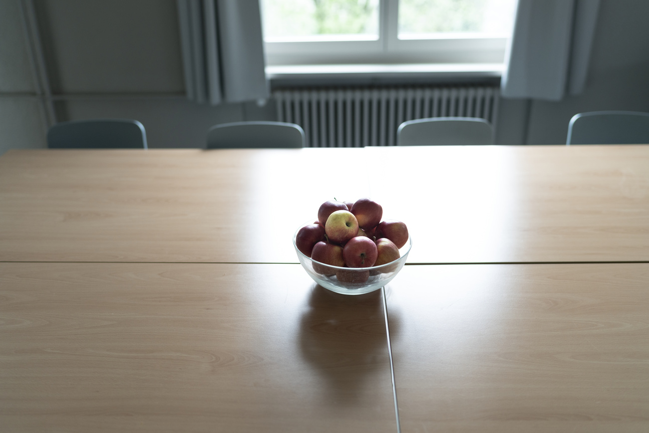 A table with a bowl full of apples.