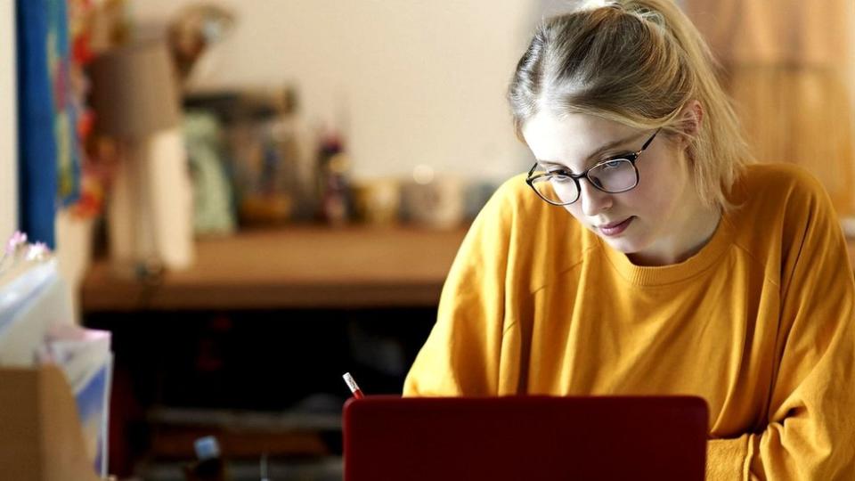 Student typing on a laptop in student accommodation