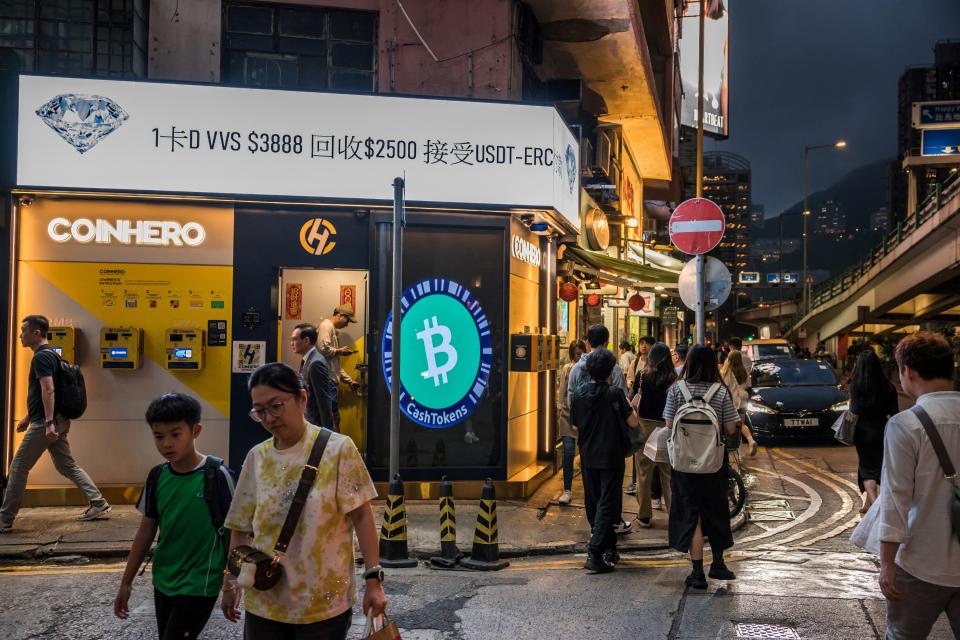 People walk past a cryptocurrency exchange in Hong Kong on April 15, 2024. In April miners of bitcoin will face a halving of the reward for operating the most popular cryptocurrency, in a pivotal event that is a test of survival, industry commentators say. (Photo by DALE DE LA REY / AFP) (Photo by DALE DE LA REY/AFP via Getty Images)