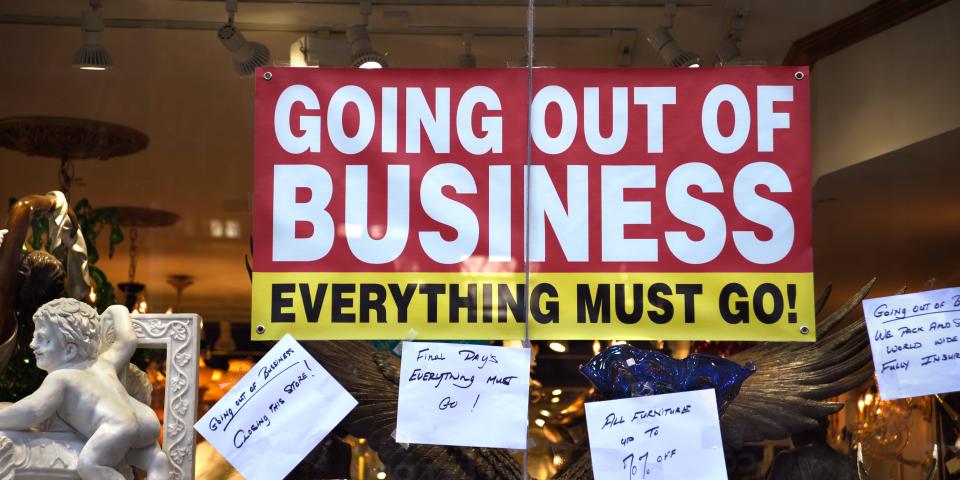 A sign in a shop window saying, "Going out of Business: Everything Must Go."