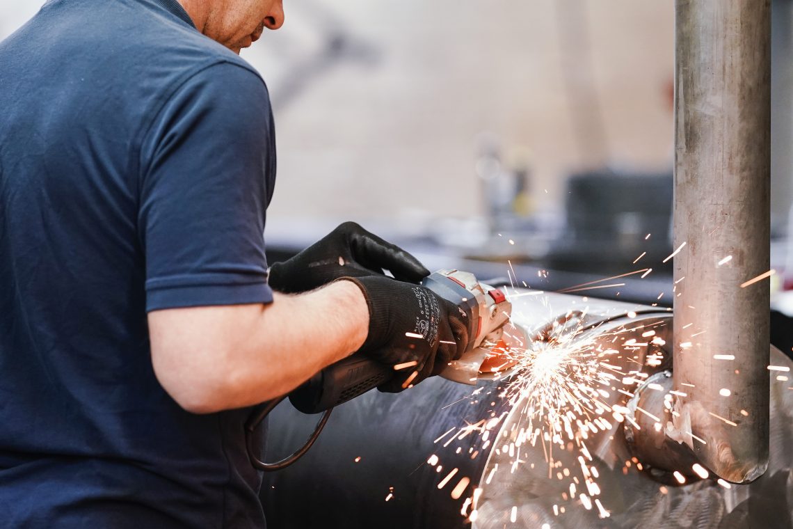 A German using a grinding machine in a locksmith’s shop.