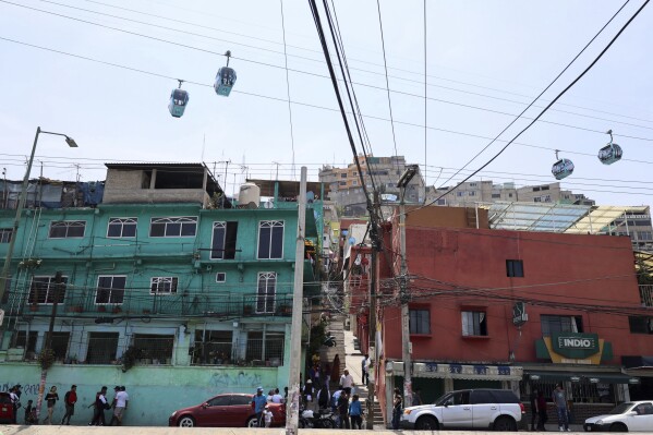 Cable cars glide over a polling station, right, during general elections in Mexico City, Sunday, June 2, 2024. (AP Photo/Ginnette Riquelme)