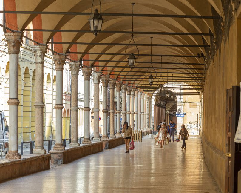 People walk along the porticoes in Bologna, July 2021