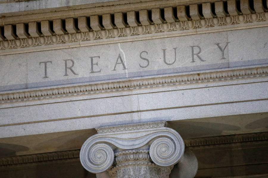 FILE- This June 6, 2019, file photo shows the U.S. Treasury Department building at dusk in Washington. The U.S. is lifting some financial restrictions on Cuba in a move designed to boost private businesses on the island. One of the key changes announced Tuesday would allow Cuban private business owners to open bank accounts in the United States and then access them online from Cuba. (AP Photo/Patrick Semansky, File)