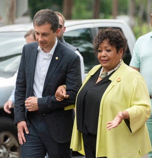 U.S. Transportation Secretary Pete Buttigieg, left, escorts Reena Evers-Everette, daughter of Civil Rights activists Medgar and Merlie Evers-Williams, to the groundbreaking of the Medgar Evers Boulevard Project in Jackson on Friday.