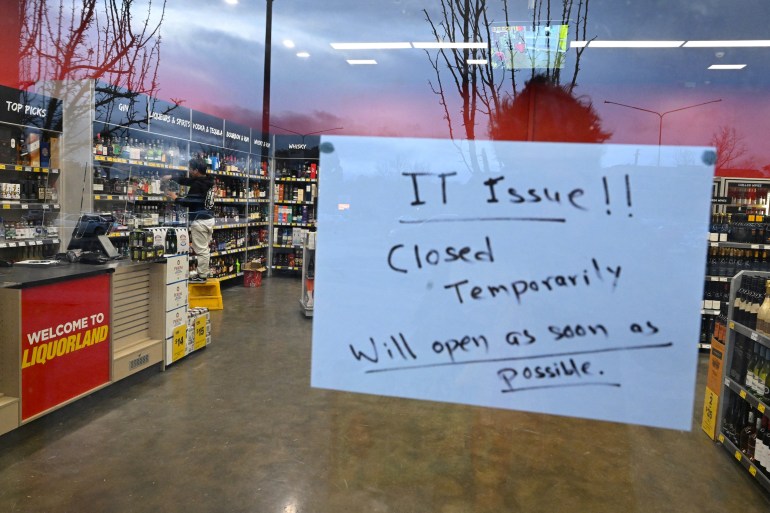A sign notifies customers of a temporary closure due to IT issues at a Liquorland store in Canberra, Australia
