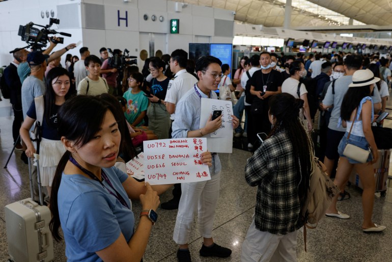 Hong Kong Express Airways passengers queue at counters in Hong Kong International Airport amid system outages disrupting the airline's operations