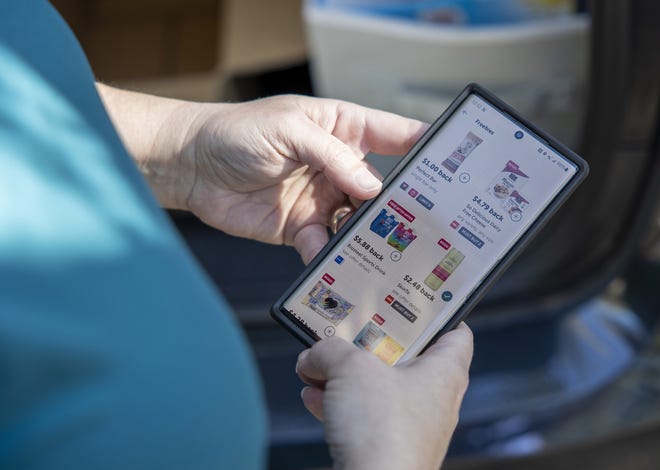 Sep 27, 2022; San Antonio, Texas, USA; Jennifer King, a â€œcouponerâ€ and budget shopper, uses her phone to check an app for rebate deals after stocking a self-serve food pantry outside of St. Lukeâ€™s Episcopal Church in San Antonio, Texas, on Tuesday, Sept. 27, 2022. Mandatory Credit: Nick Wagner-USA TODAY