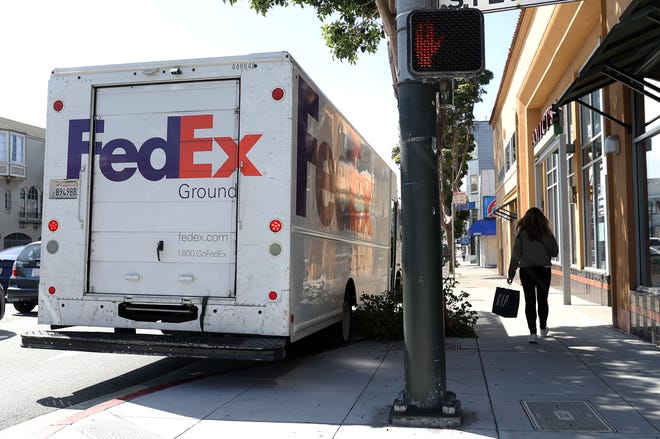 A pedestrian walks by a parked FedEx delivery truck on March 21, 2024 in San Francisco, California.