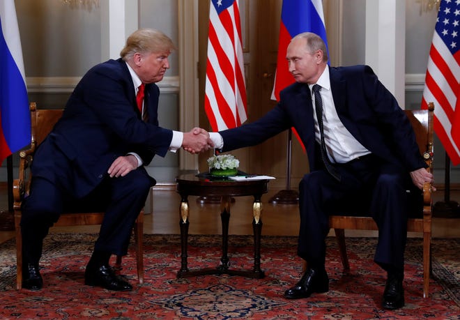 President Donald Trump and Russia's President Vladimir Putin shake hands as they meet in Helsinki, Finland, on July 16, 2018.