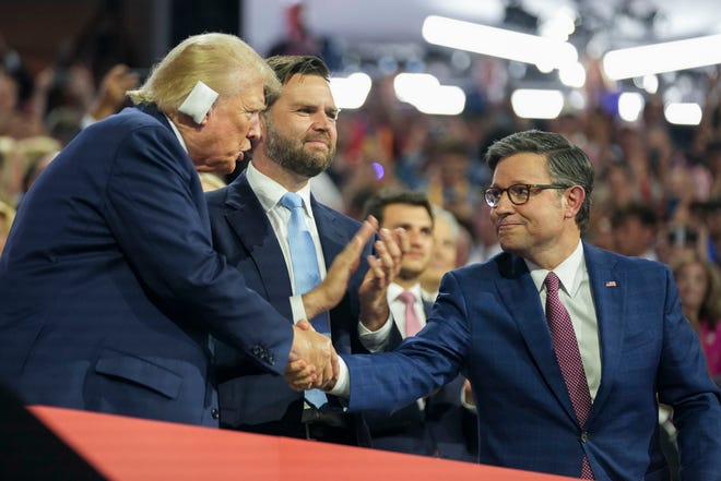Former President Donald Trump shakes hands with House speaker Mike Johnson (right) with Trump’s Vice Presidential pick JD Vance (center) at the Republican National Convention on July 15, 2024, in Milwaukee, Wis.