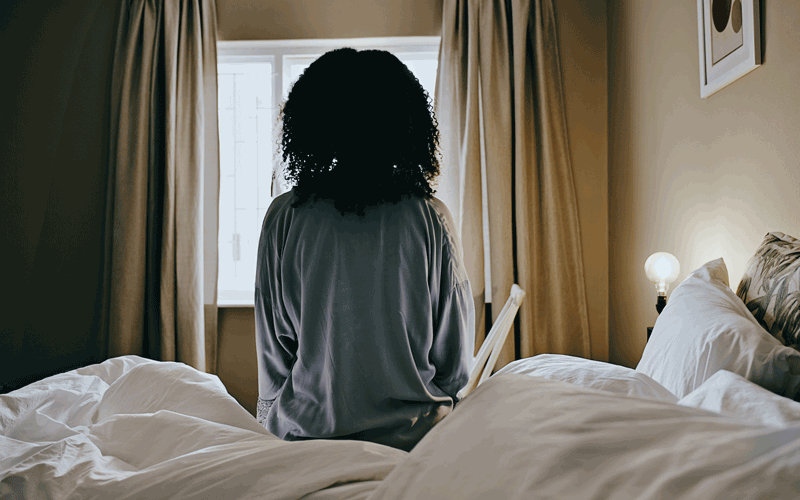 woman sitting bed - credit - istock-1462664399